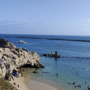 Coastal Escape – Sunny Beach Cove with Swimmers